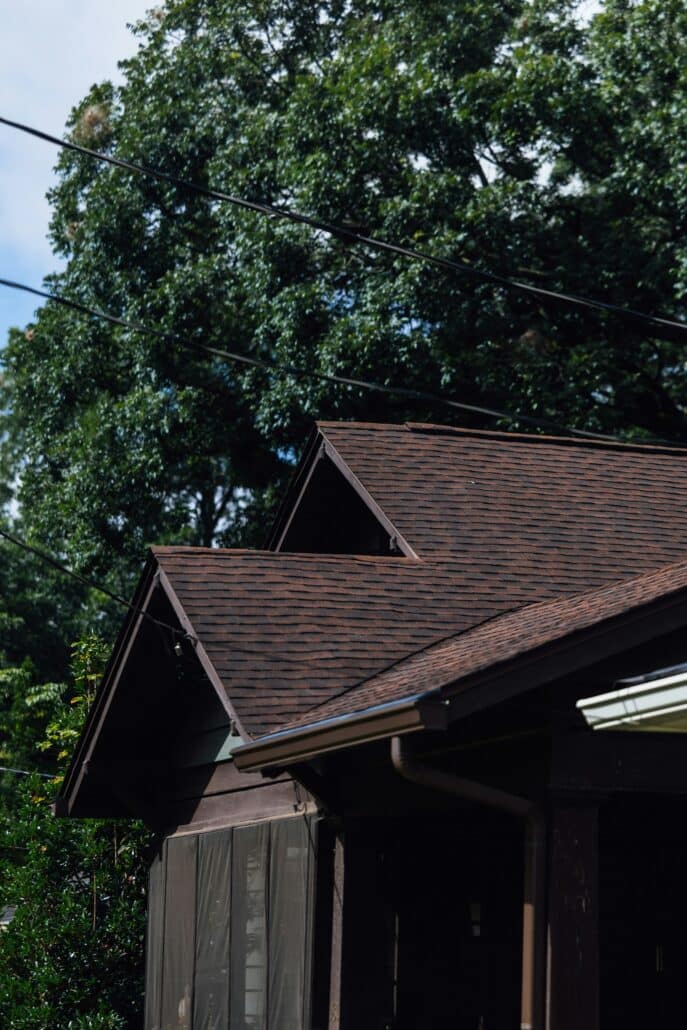 Brown asphalt shingle roof on a suburban home with trees, typical of Minnesota homes before winter