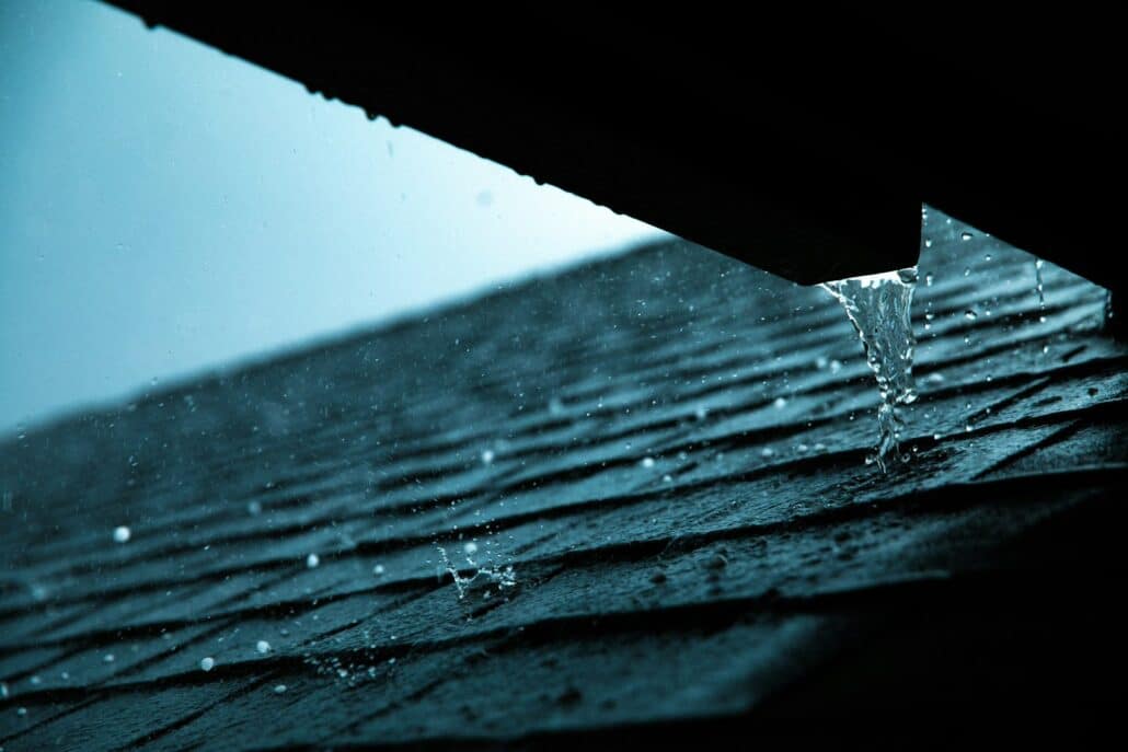 Close-up of a rain gutter along a roof edge that needs fall cleaning before winter